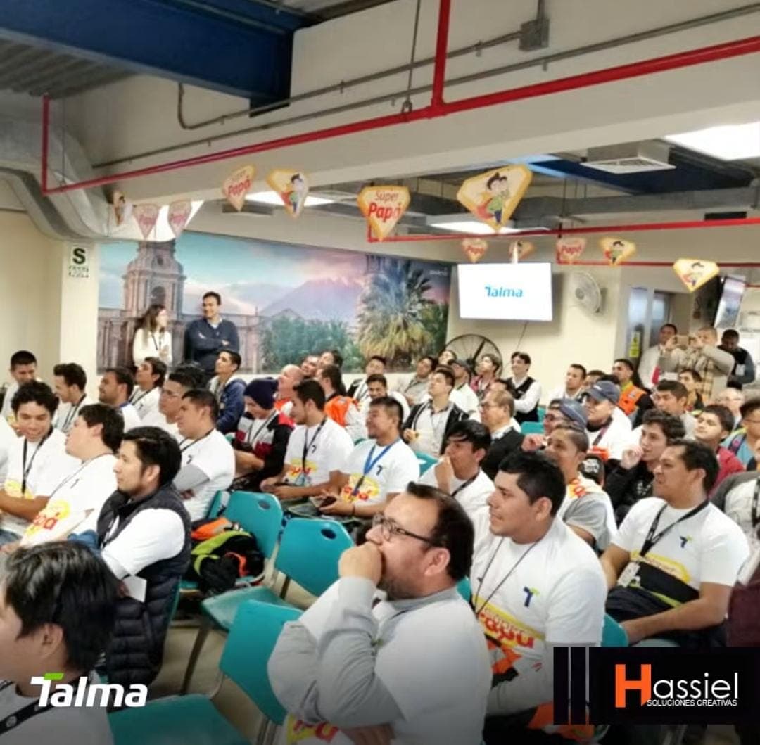 Grupo de empleados sentados en una sala decorada con carteles festivos de Súper Papá.