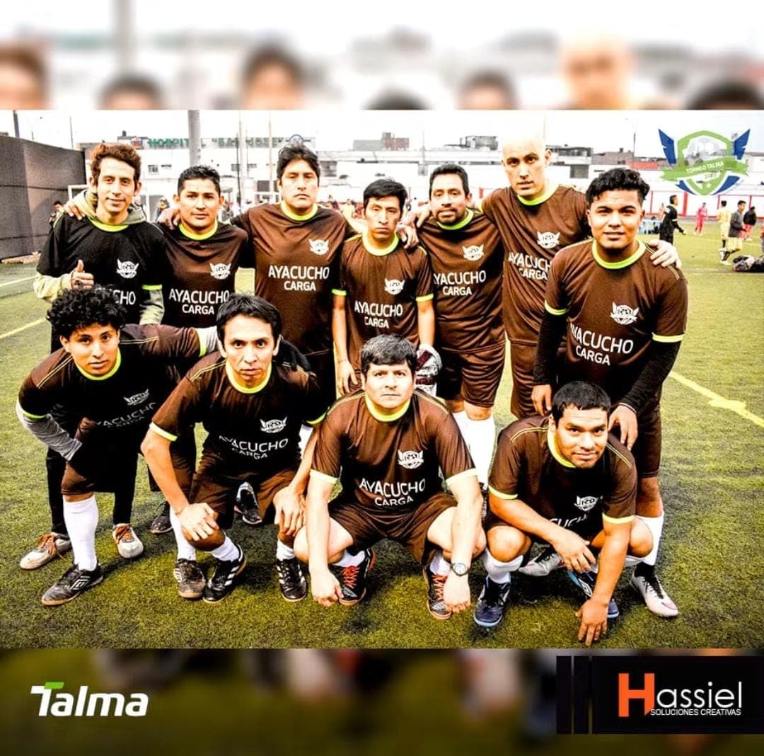 Jugadores de fútbol con uniformes marrones de Ayacucho Carga posando en un campo verde.