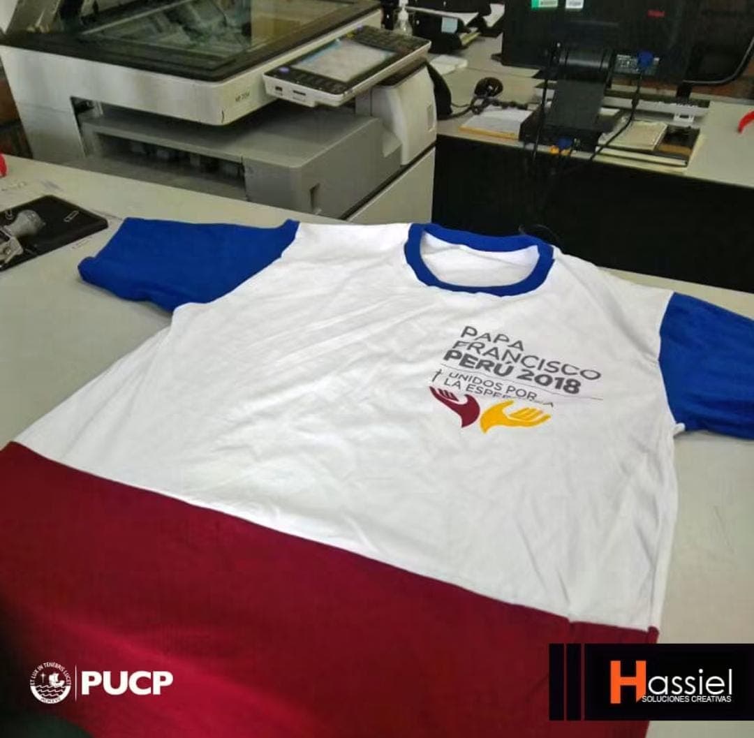 Polo blanco con mangas azules y base roja del evento Papa Francisco Perú 2018.